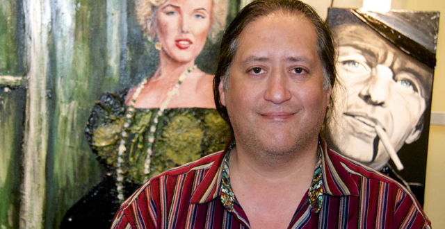 Artist Richard Nuñez stands before his Marilyn Monroe painting that was shot up. 