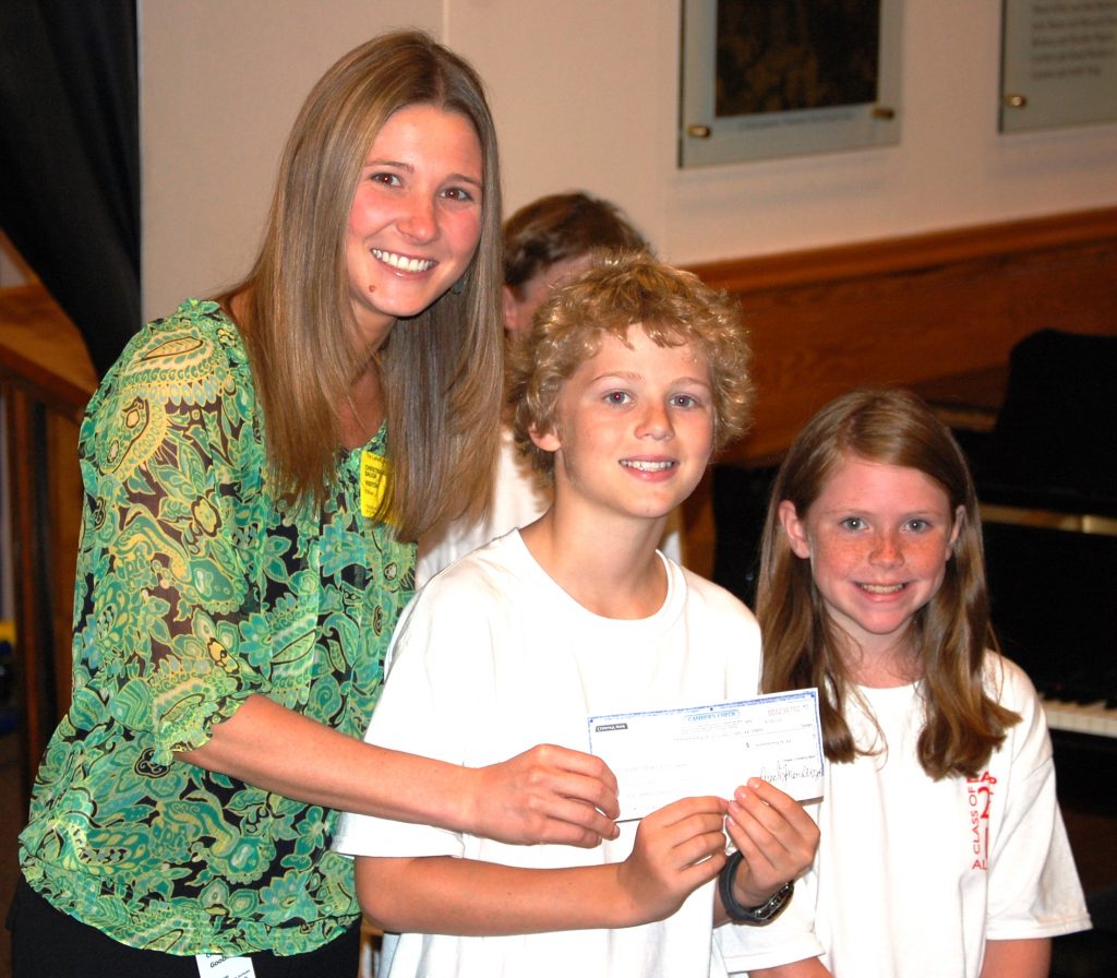 Christina Goodman accepts a check worth $478 for James Carr and Victoria Harper. 