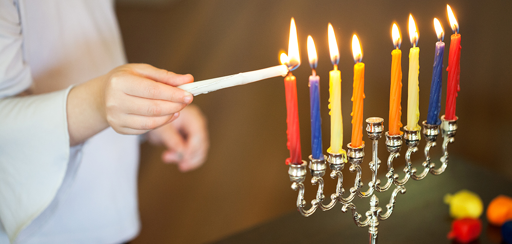 Girl lighting the Menorah for Hanukkah