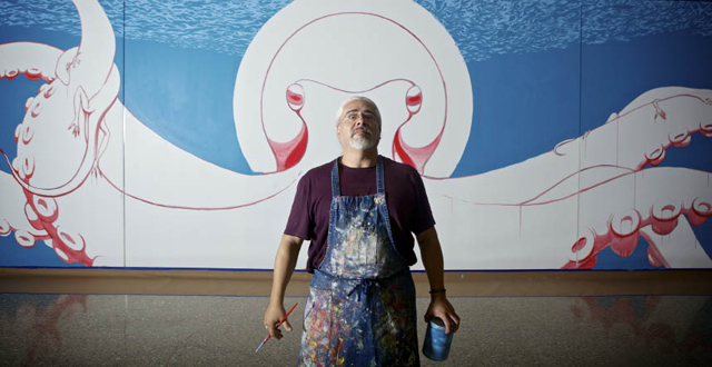 Artist Kevin Obregon stands in front of his massive “Oztopus” mural in the artist’s wing 