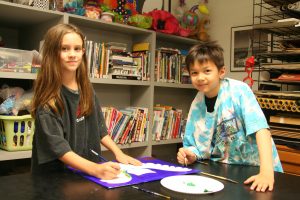 Alcuin Students and Preston Hollow residents Sophie Johnson and Nicholas Dai work during art class to prepare their paintings for display at Zoës Kitchen