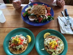 a photo of Coconut Grill Cafe's Ono salad and fish tacos via yelper Arsham G. 