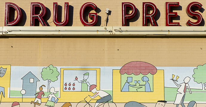 The Dougherty’s Pharmacy neon sign, along with the mural painted in 2008, is a neighborhood landmark to some. Photo by Danny Fulgencio