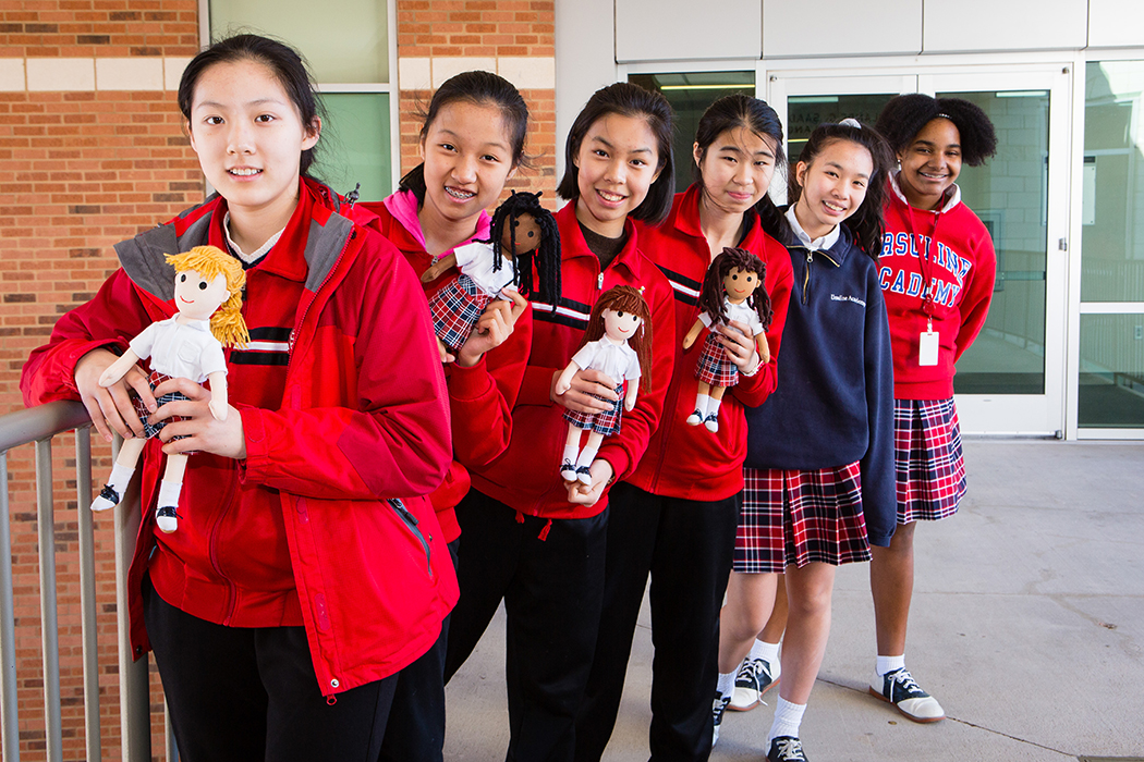 Students from Ursuline and Beijing Hauxia Girls School pose with Ursuline’s little traveler dolls. (Photo by Vonda Klimaszewski)